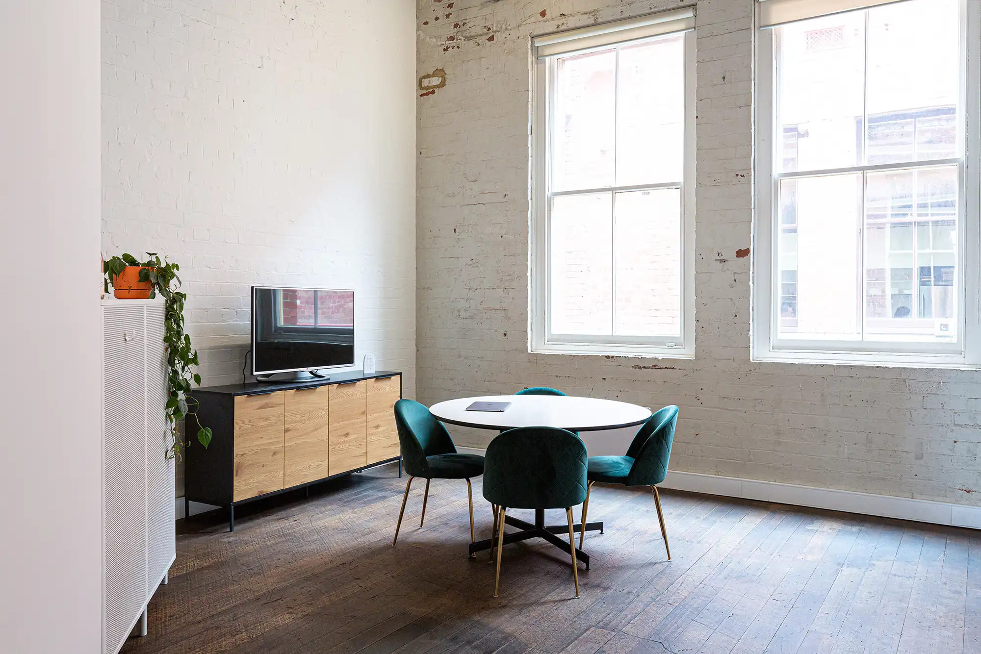 The Lightyears meeting area, large vicorian industrial windows illuminate a meeting desk